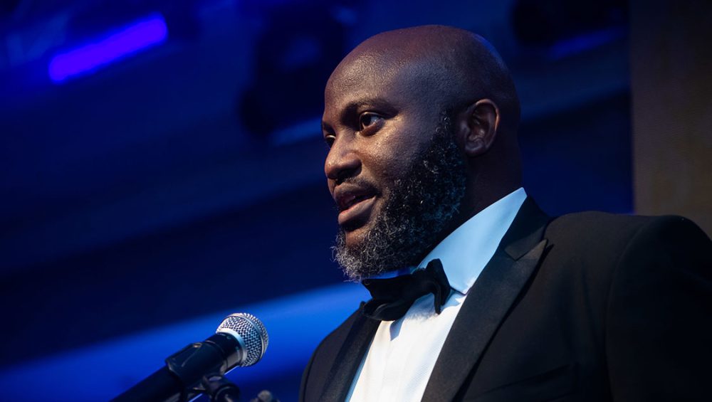 Dozy at an event speaking into a mic